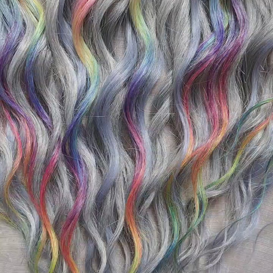 Silver Rainbow - soft, lightweight, and reusable synthetic brushable double ended wavy dreadlocks (regular dreaded, braided middle, or push-up).

A silver-grey base with vibrant rainbow accents. Bright pops of color stand out against the cool smoky background, creating a playful yet balanced look.