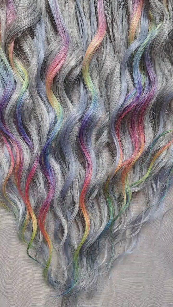 Silver Rainbow - soft, lightweight, and reusable synthetic brushable double ended wavy dreadlocks (regular dreaded, braided middle, or push-up).

A silver-grey base with vibrant rainbow accents. Bright pops of color stand out against the cool smoky background, creating a playful yet balanced look.