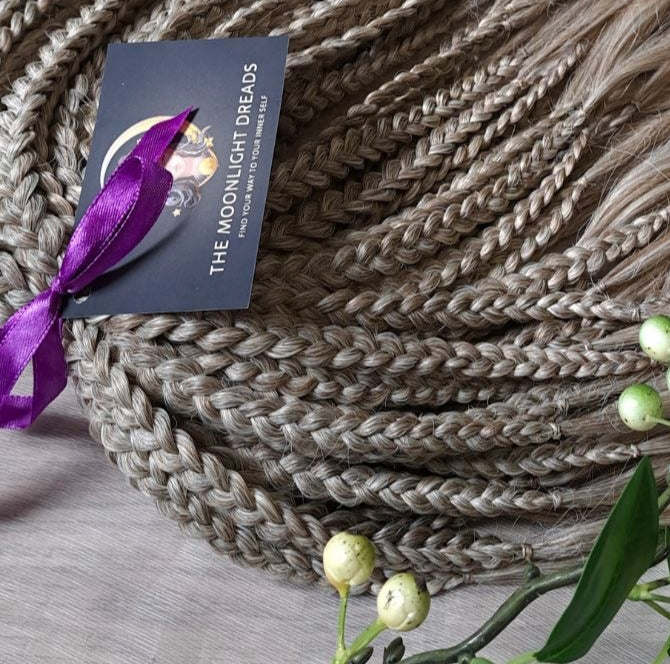 Ready to ship: soft, lightweight, and reusable 50 double ended synthetic brushable curls with braided middle. Soft natural gradient in warm neutral tones.

Roots in muted dark blonde with a subtle ash-beige (taupe) undertone, gradually blending into a warm beige-wheat blonde, and finishing in a light creamy, almost platinum vanilla blonde at the ends.