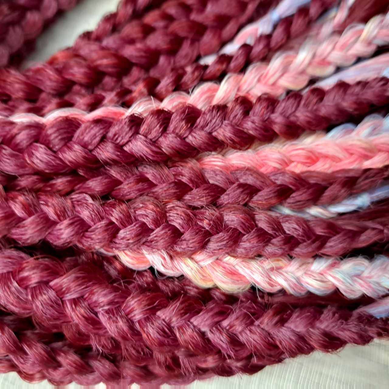 Deep berry red base with pastel highlights in blue, lilac, pink, and soft yellow - bold contrast with a smooth flow of color. Soft, lightweight, and reusable synthetic brushable double ended wavy dreadlocks. Bring the burst 💥
